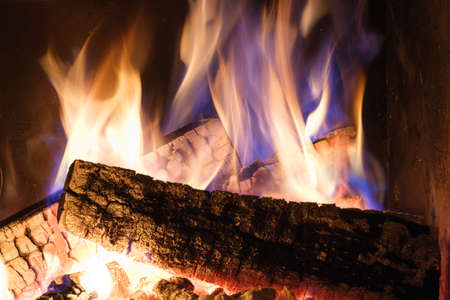 A fireplace with burning logs. Fire in the fireplace. A cozy place to rest. Winter time.