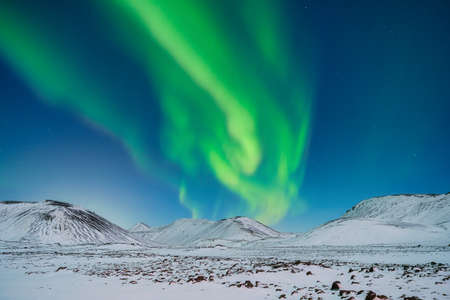 Aurora Borealis. Northern Lights over the mountains. A winter night landscape with bright lights in the sky. Landscape in the north in winter time. A popular place to travel.の写真素材