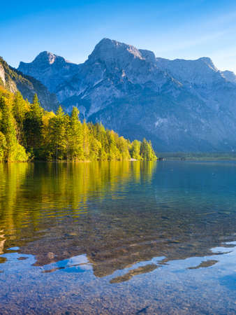 High mountains and reflection on the surface of the lake. The forest near the water. Landscape in...