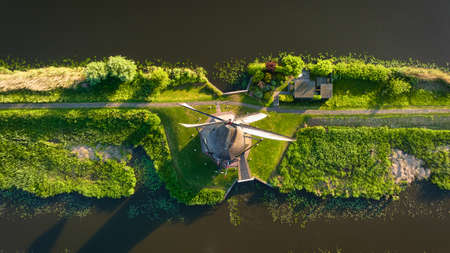 An aerial view of the windmill. Kinderdijk national park. Canals with water for agriculture. Fields and meadows. Landscape from the air.の写真素材