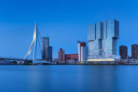 Rotterdam, Holland. View of the Erasmus Bridge and the city center. Long exposure photography. Cityscape in the evening. Skyscrapers and buildings.の写真素材