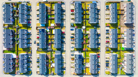 An aerial view of the houses and streets. A residential area in the suburbs. Houses and private yards. View of townhouses from the drone. Photo for building design.の写真素材