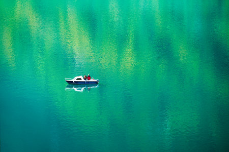 Fishing from a boat. Boat on the lake and reflections on the surface. Summer holidays and hobbies. Nature in summer time.の写真素材