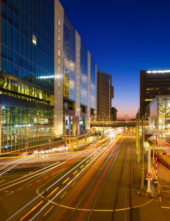 The city at night. Buildings and skyscrapers. The business center. The lights from cars as they drive by. Wide format photography. Fast city traffic.の写真素材
