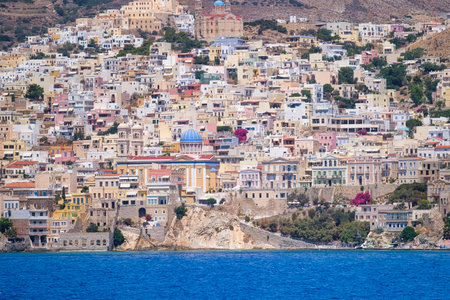 Ermoupolis town, Greece. A town on the side of a mountain. Houses and streets in Greek architecture. Photography for travel and adventure. Cascading arrangement of buildings on the hillside.の写真素材