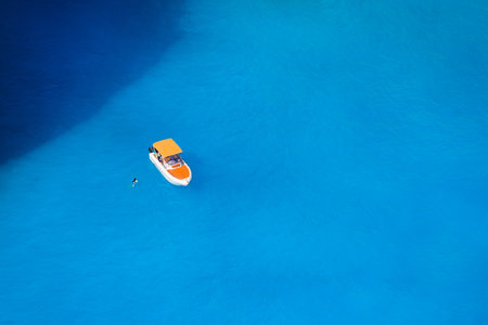 A boat in the lagoon. View of the sea bay and a lone boat from a drone. Blue sea water. Vacation and travel. Summer landscape from the air.の写真素材