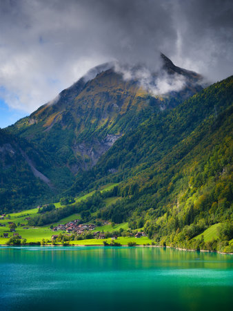 Lungern, canton of Obwalden, Switzerland. A view of rural homes in a green meadow. A lake in a mountain valley. A popular place to travel.の写真素材