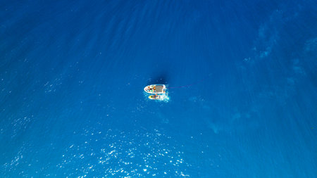 Seascape with boats. Aerial view of floating boat on blue sea at sunny day. Nautical vessel. Top view from drone on the azure sea. Travel and vacation imageの写真素材
