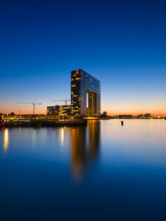 Amsterdam, Netherlands. A cityscape in the evening. A skyscraper and business center near the water in the bay. Architecture of the Netherlands. Travel photography.の写真素材