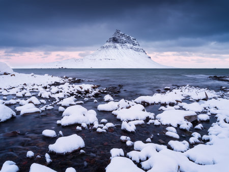 Kirkjufell mountain, Iceland. Winter landscape. The mountain and the ocean. Snow and ice. A popular place to travel in Iceland.の写真素材