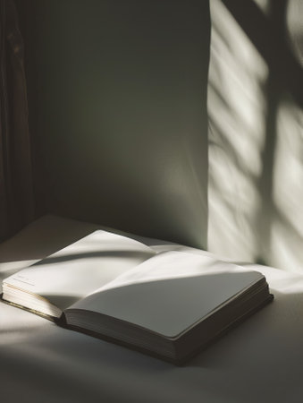 Open book on white table with sunlight and shadows. Vintage tone.の素材