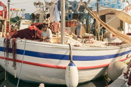 Paros, Greece 15 August 2015. Fisherman on a boat fixing the fishing net at Paros island in Greece.のeditorial素材