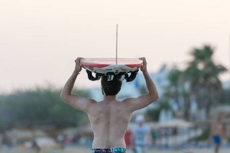 Surfer with the surf on his head going to chase the waves.