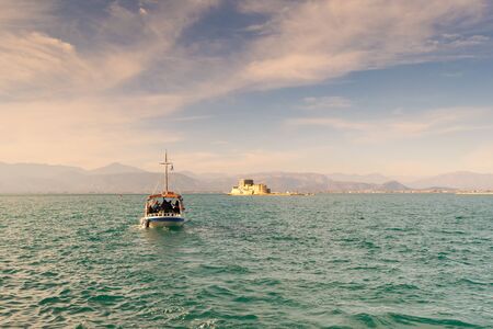 Boat with local people and tourists going to Bourtzi castle for a tour at Nafplio in Greece.の写真素材