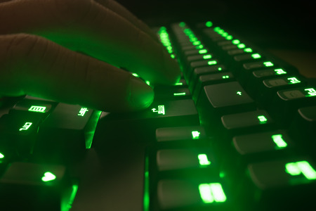 Man typing on green keyboard.の写真素材