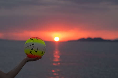 Beach volleyball against a dramatic and vivd sunset during summer.の写真素材