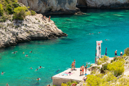 Zakynthos, Greece 27 July 2023. Porto Limnionas beach in Zakynthos island in Greece with local people and tourists enjoying summer.のeditorial素材