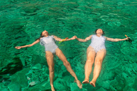 Mother and daughter enjoying summer at blue caves in Zakynthos island in Greece wearing the same swimsuit.の写真素材