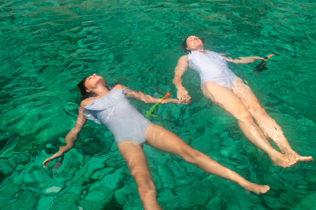 Mother and daughter enjoying summer at Zakynthos island in Greece wearing the same swimsuit.の写真素材