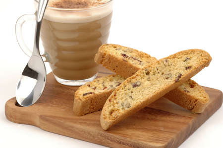 Tasty biscotti and cappuccino served on a wooden board.の写真素材