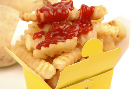 Yello cardboard box of fries with ketchup.