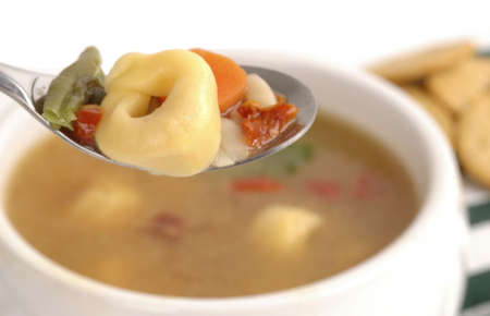 Close-up of hearty vegetable soup with tortellini.の写真素材