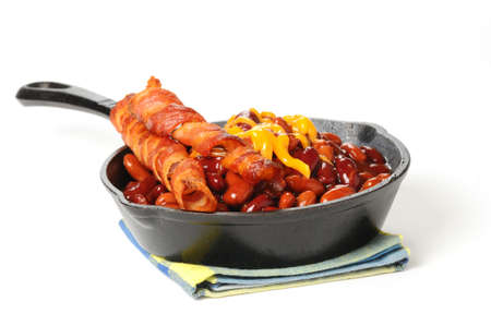 Baked beans and bacon served in a cast iron skillet.の写真素材