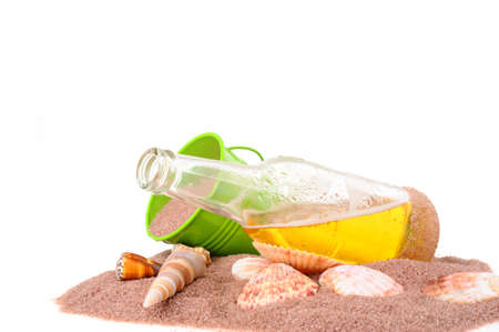 Open bottle of beer with sand and shells.の写真素材