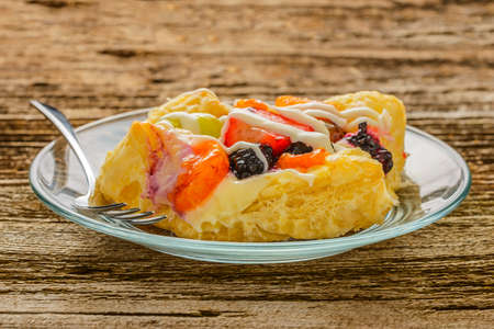 Glazed fresh fruit and custard on white pastry.の写真素材