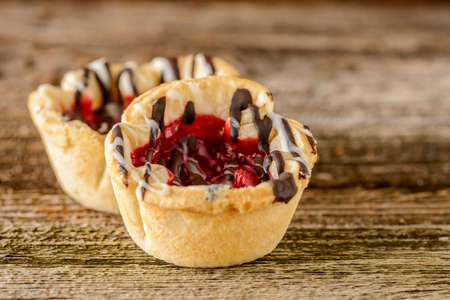 Homemade cherry tarts with chocolate and vanilla icing.の写真素材