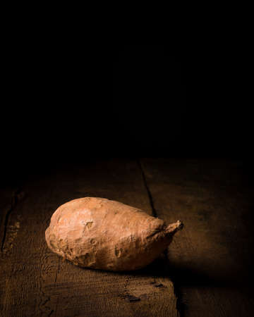 Single yam photographed on a low key backgroundの写真素材