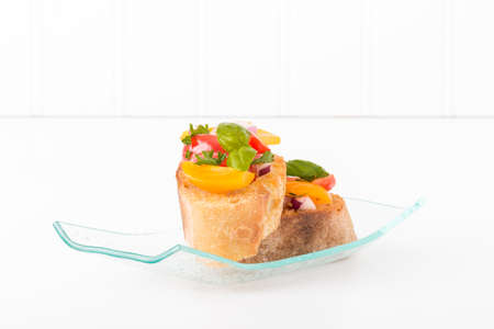Colorful bruschetta on a glass plate.  Suitable for many food service promotional materials.の写真素材