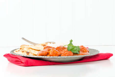 Plate with Indian butter chicken, rice and nan bread.の写真素材