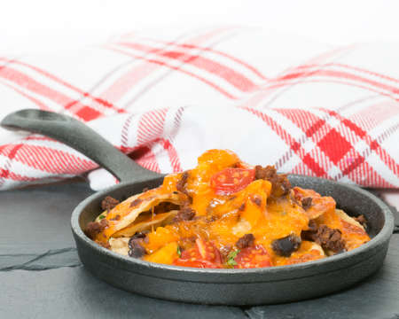 Delicious nachos served in a small cast iron fry pan.の写真素材