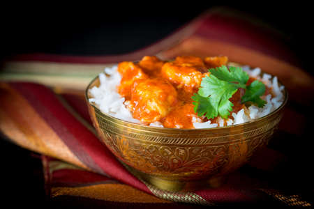 Bowl of butter chicken on a bed of basmati rice.の写真素材