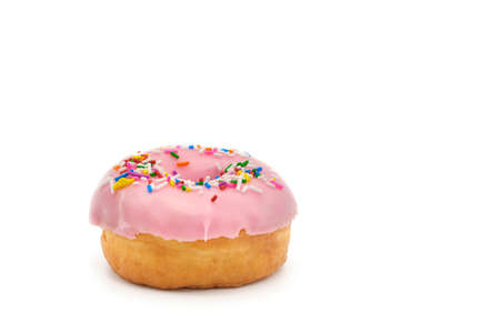 Single donut with pink icing and colorful sprinkles photograph on a white background with ample copy space.の写真素材