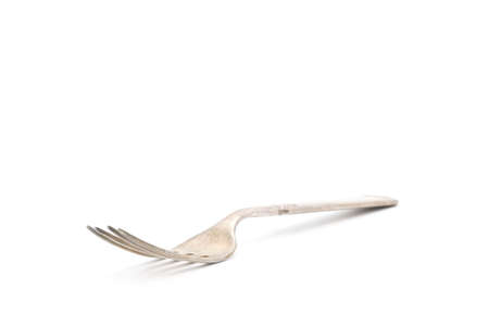Well used vintage fork photographed on a white background with ample copt space.の写真素材
