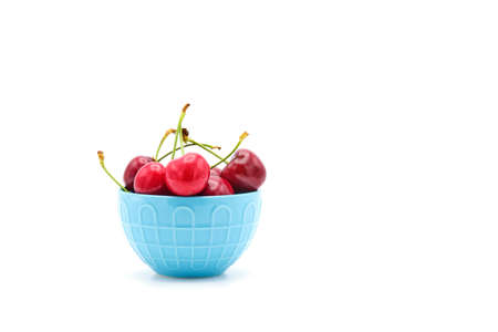 Fresh whole sweet red cherries photographed on a while background with ample copy space.の写真素材