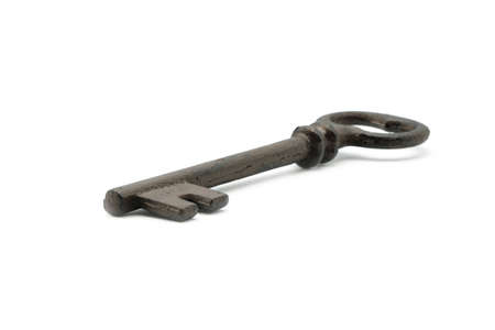 Rusty old skeleton key photographed on a white background with a shallow depth of field.