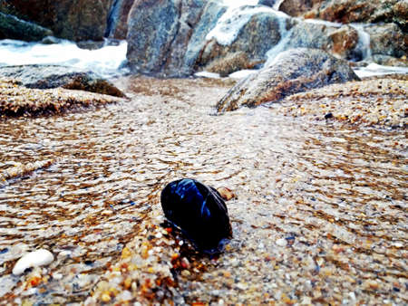 Foam against the rocks in the seaの写真素材