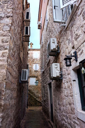 Narrow cobbled street with stairs along medieval stone wall in Old Budva, Montenegro.の写真素材