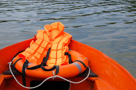 Outfit of lifeguard on water in summer boat, life jacket, lifebuoy in orange color. Rescue on water...