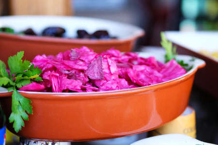 Red sauerkraut  in street side restaurant. Purple pickled cabbage. Street food and outdoor cooking concept.の写真素材