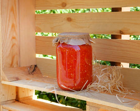 Glass jar with homemade fermented red tomato sauce. Healthy natural food concept.の写真素材