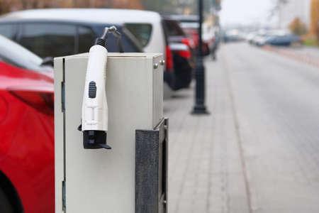 Electric vehicle charger station installed in parking lot in modern residential area. Eco friendly...