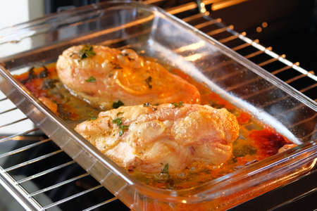 Process of cooking spicy chicken fillet in oven. Chicken breast is fried, cooking process. Close up.の写真素材