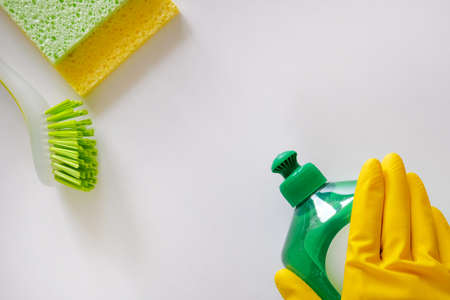 Cleaning service concept. Cleaning set with green tools on light background. Top view cleaning...