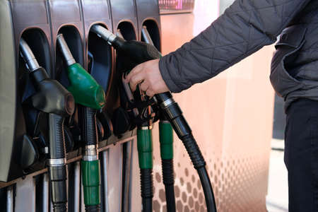 Man fills up his car with a gasoline at gas station. Petrol station pump. To fill car with fuel. Gasoline and oil products.の写真素材