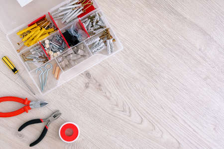 Flat lay of red tools, parts and screwdrivers on white wooden background, close up. Diy repair in...