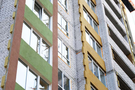 White brick multi-family house under construction. Exterior view of new house under construction. Construction site.の写真素材